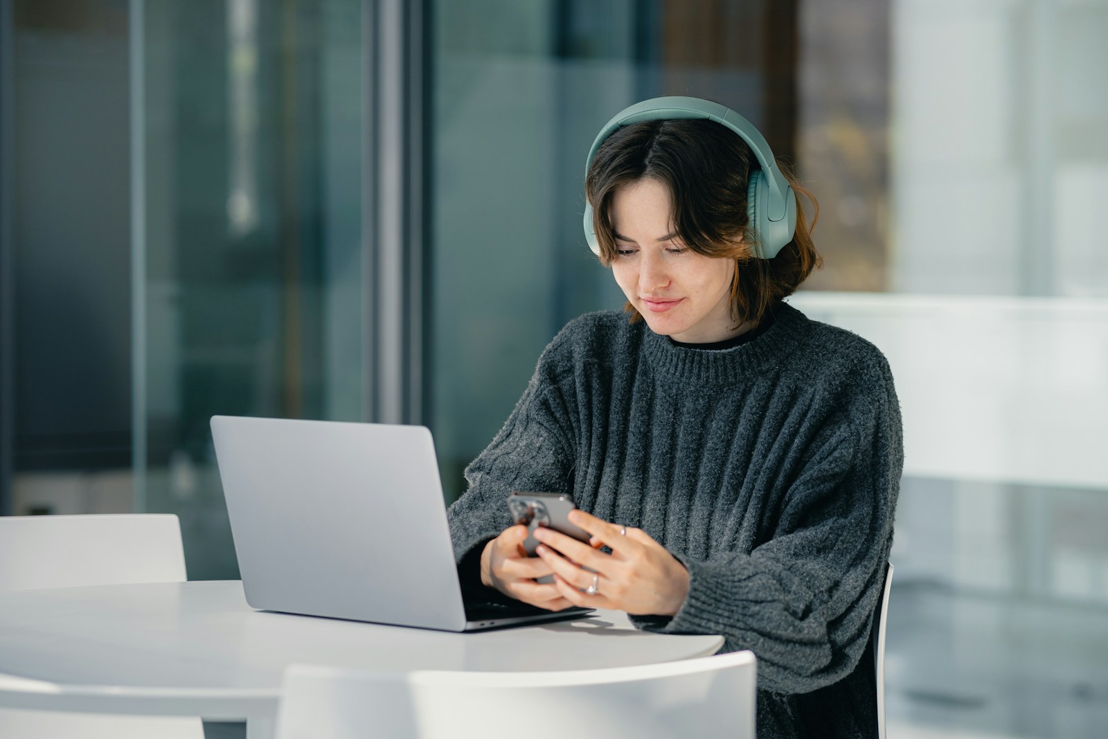 A woman sitting at a table using a laptop computer